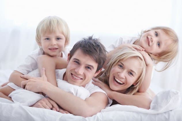 Familie beim Kuscheln im Bett